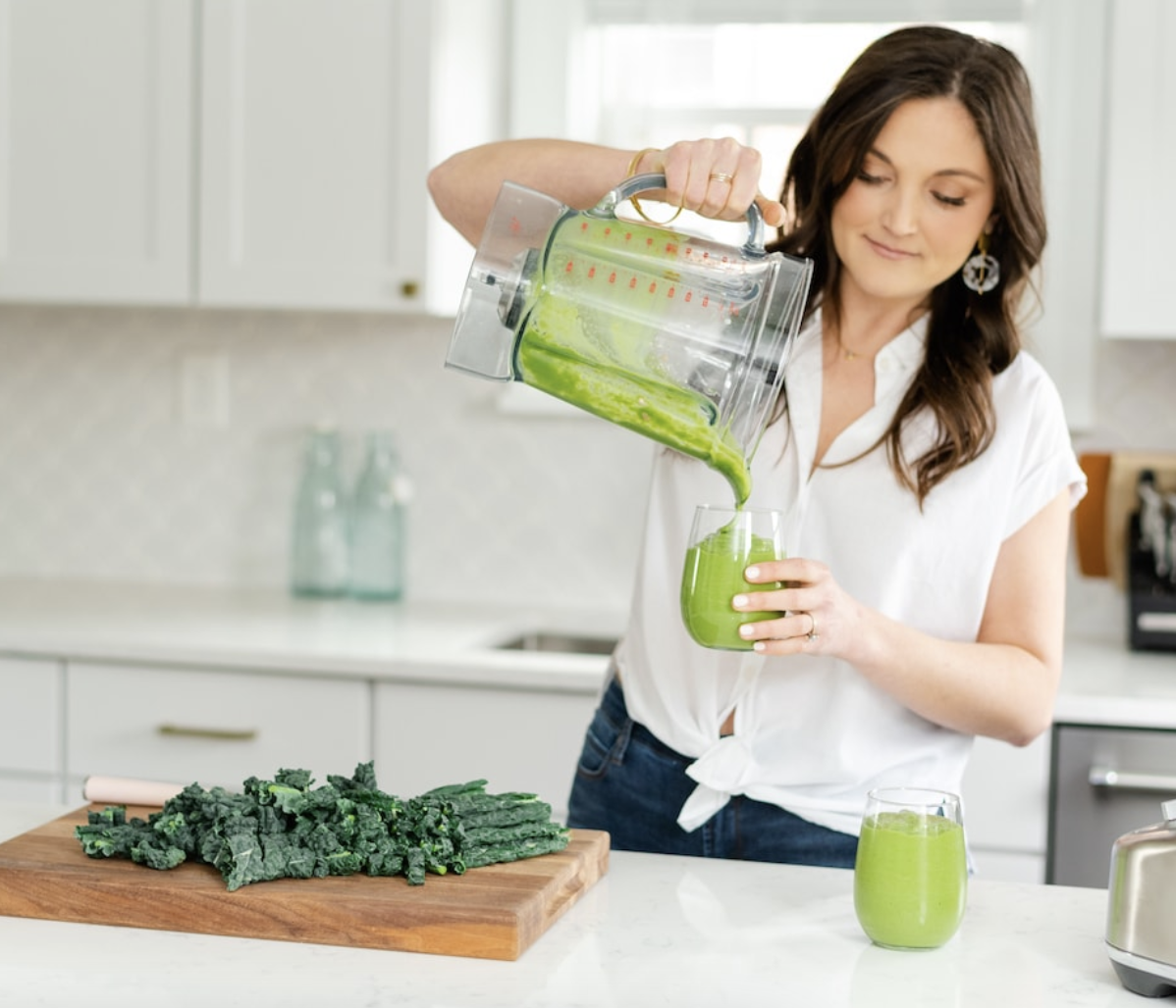 Brunette woman pouring green smoothie